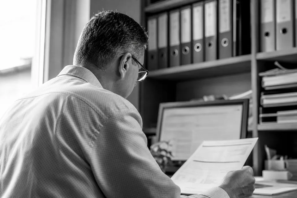 Księgowa sprawdza dane firmy w rejestrze na monitorze w biurze rachunkowym